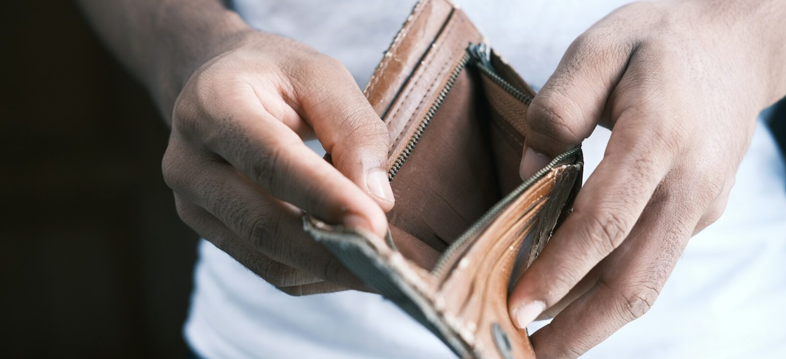 person holding brown leather bifold wallet