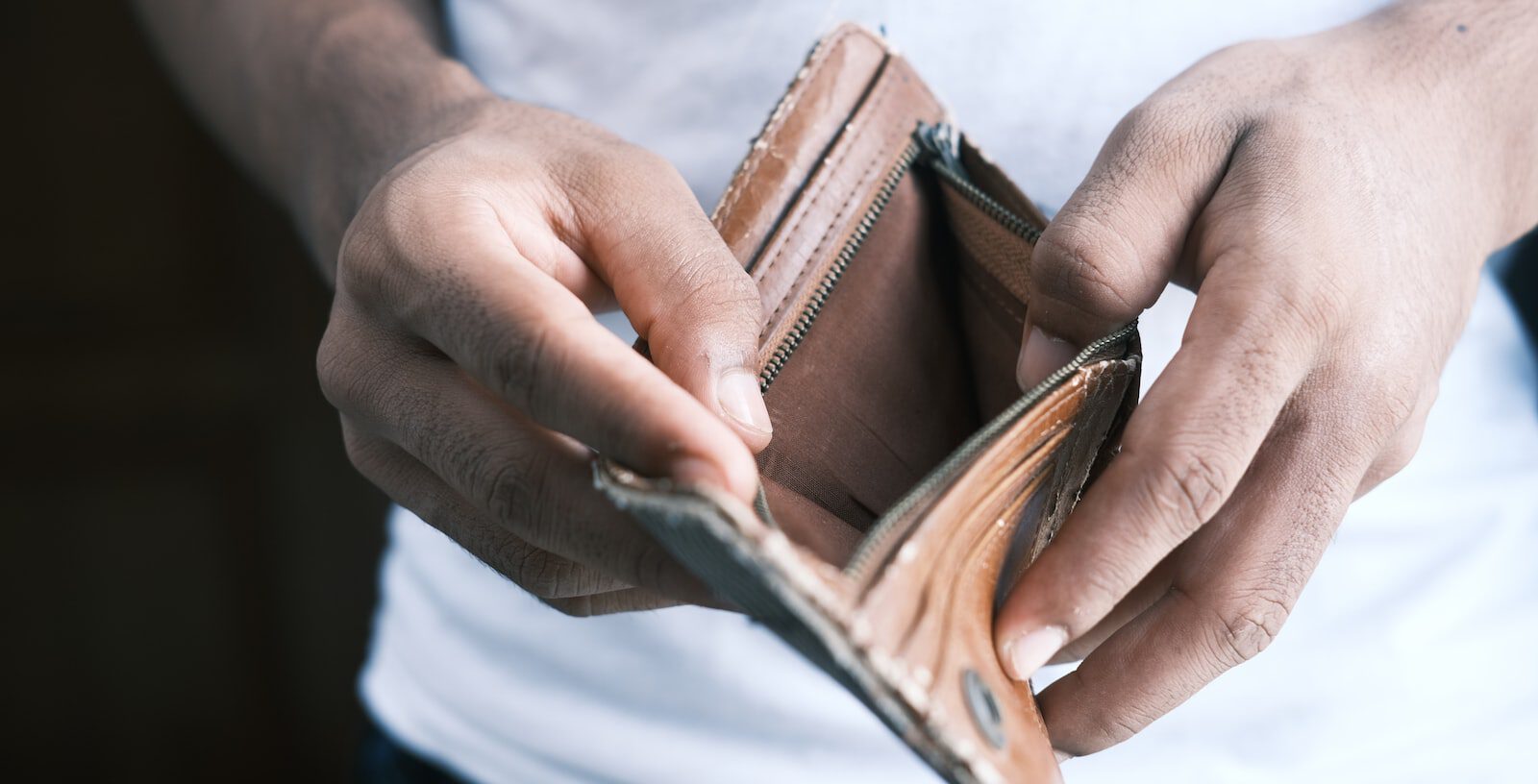 person holding brown leather bifold wallet